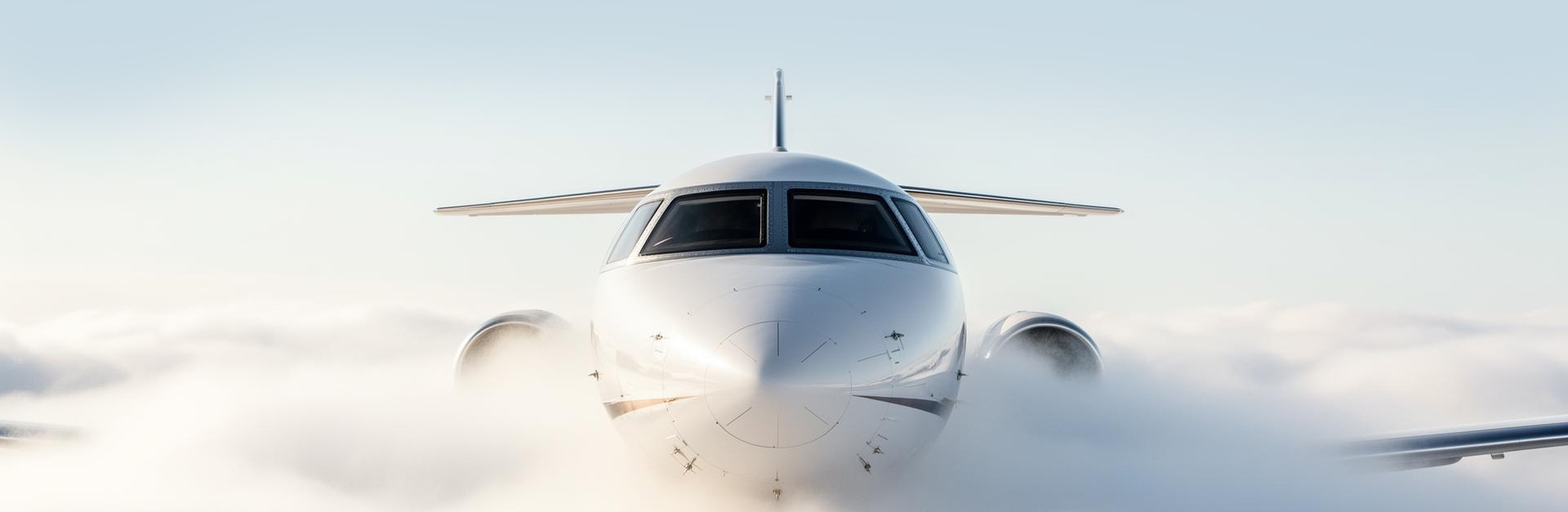 Luxury private jet emerging from the clouds